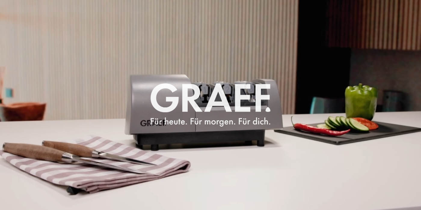 Graef knife sharpener with vegetables and knives on a countertop