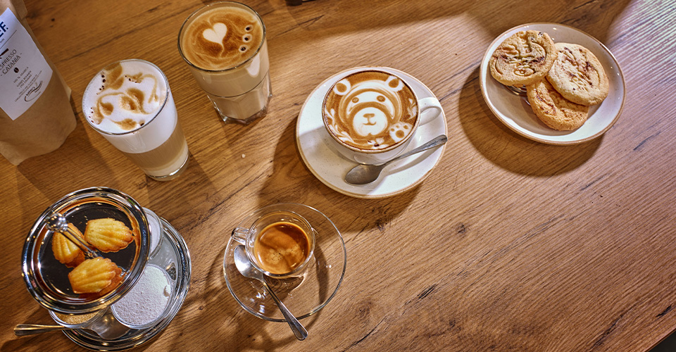Kaffee, Gebäck und Holzoberfläche. Verschiedene Kaffeesorten und Kekse auf einem Holztisch.