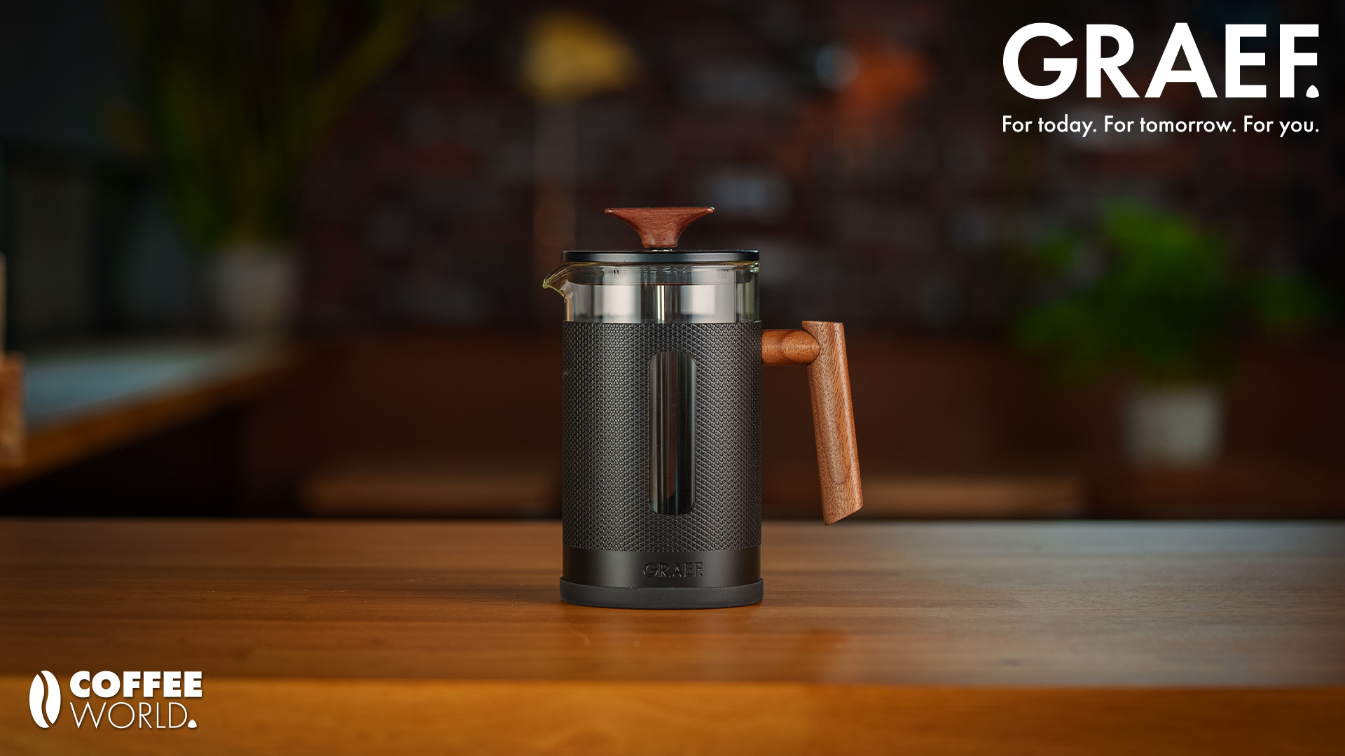 GRAEF coffee maker with wooden handle on a wooden table, COFFEE WORLD logo.
