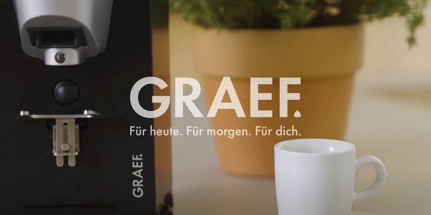 Kaffeemaschine mit Tasse und Topf mit Pflanze, GRAEF-Logo