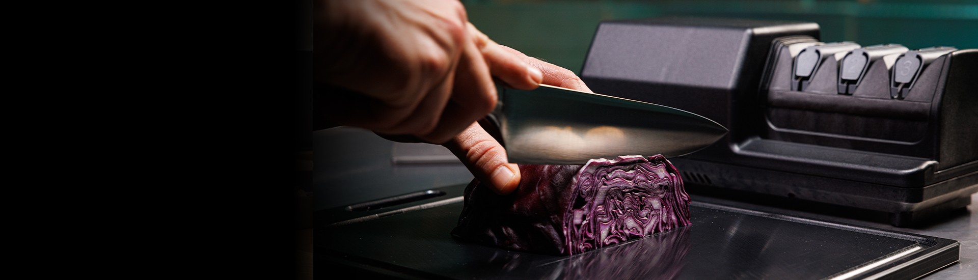 Messer schneidet Rotkohl auf Schneidebrett, daneben Messerschärfer.