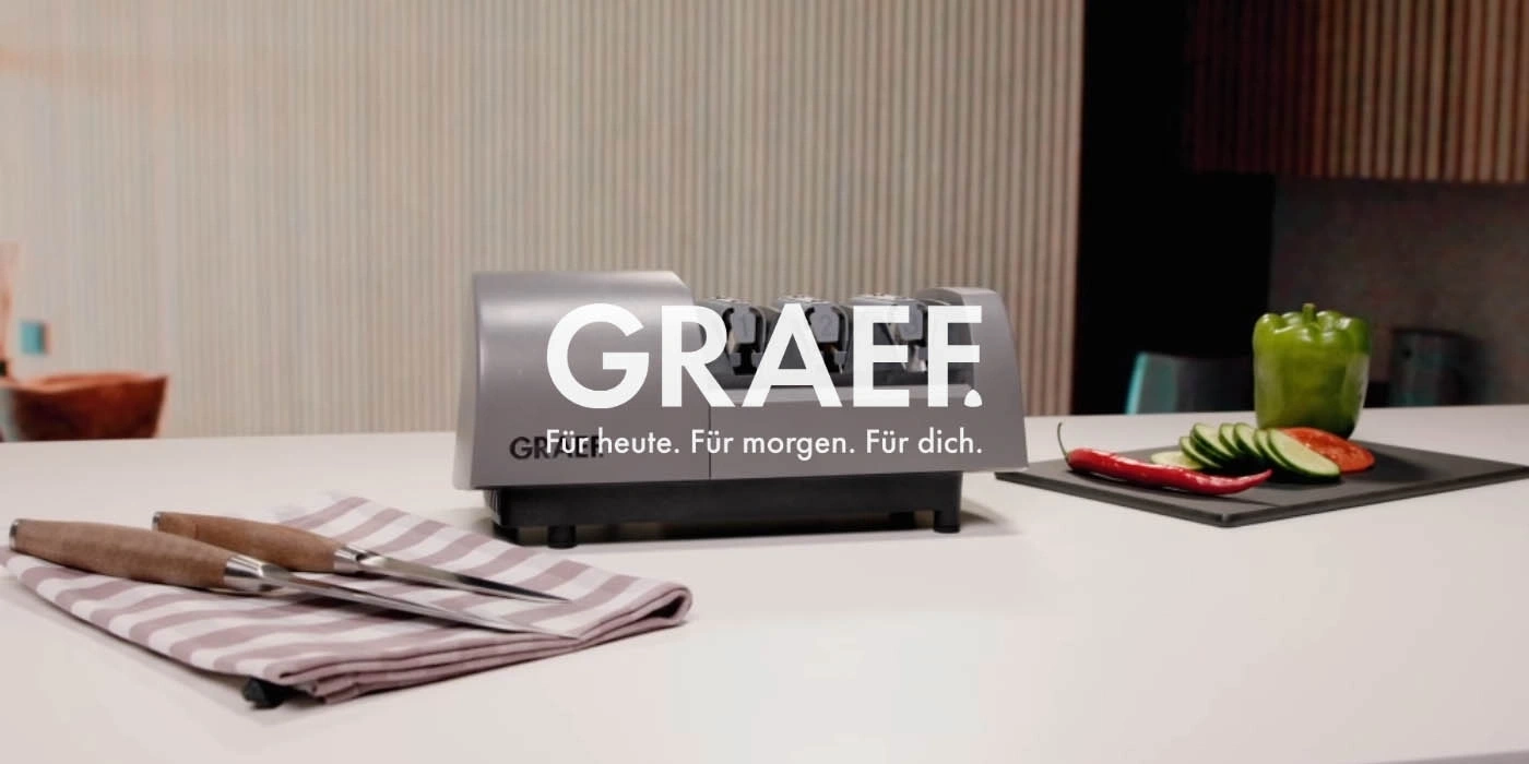 Graef knife sharpener with vegetables and knives on a countertop
