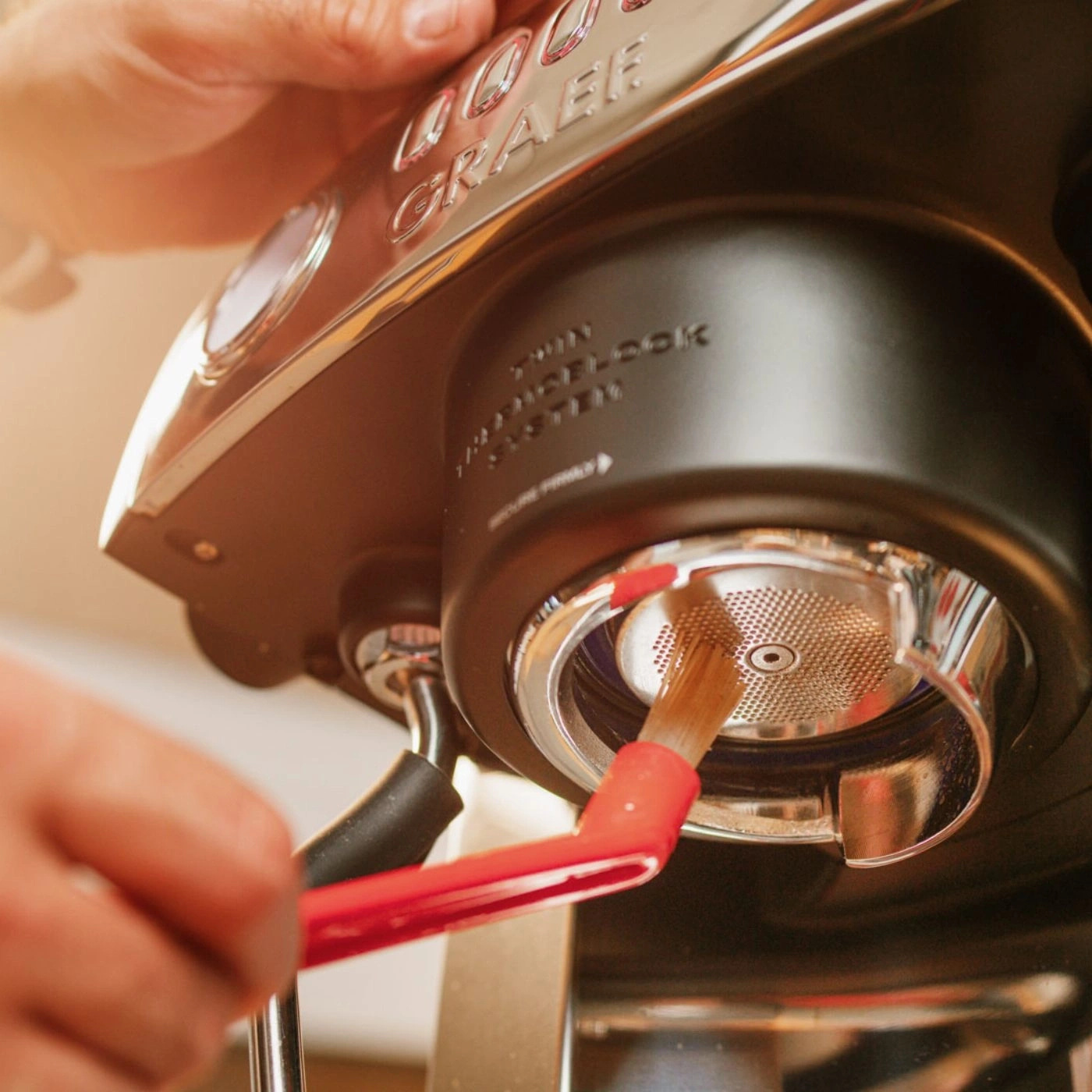 Cleaning an espresso machine with a brush. Close-up of the machine being cleaned.