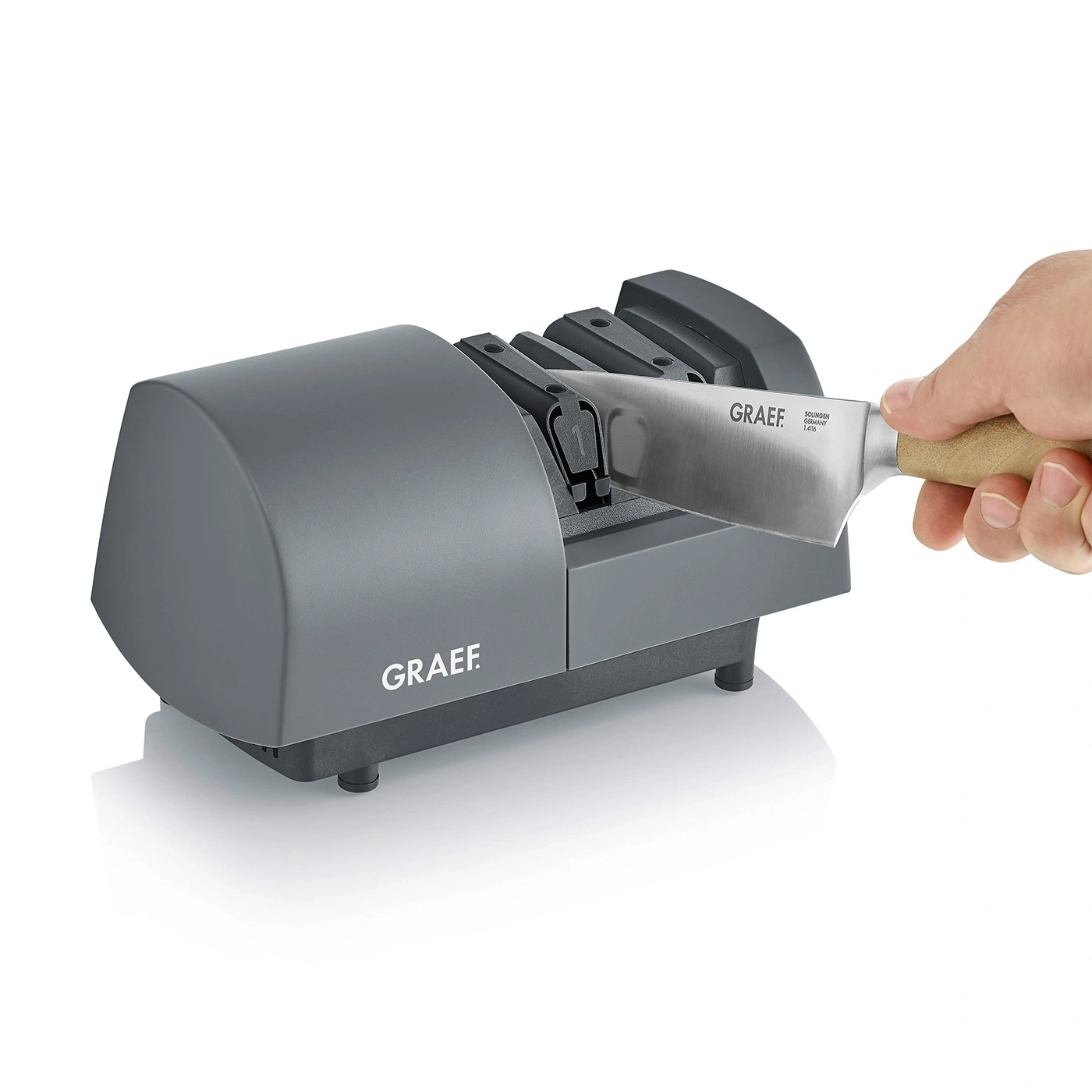 Graef Messerschärfer mit Messer, Hand hält Messer, graue Maschine, weißer Hintergrund