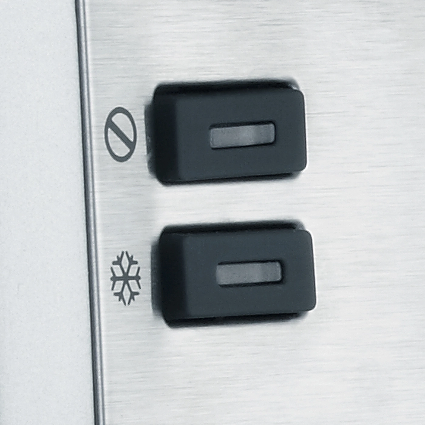 Zwei schwarze Knöpfe mit Symbolen auf einer Metalloberfläche.