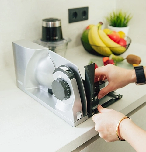 Electric slicer with fruits and vegetables on the kitchen counter