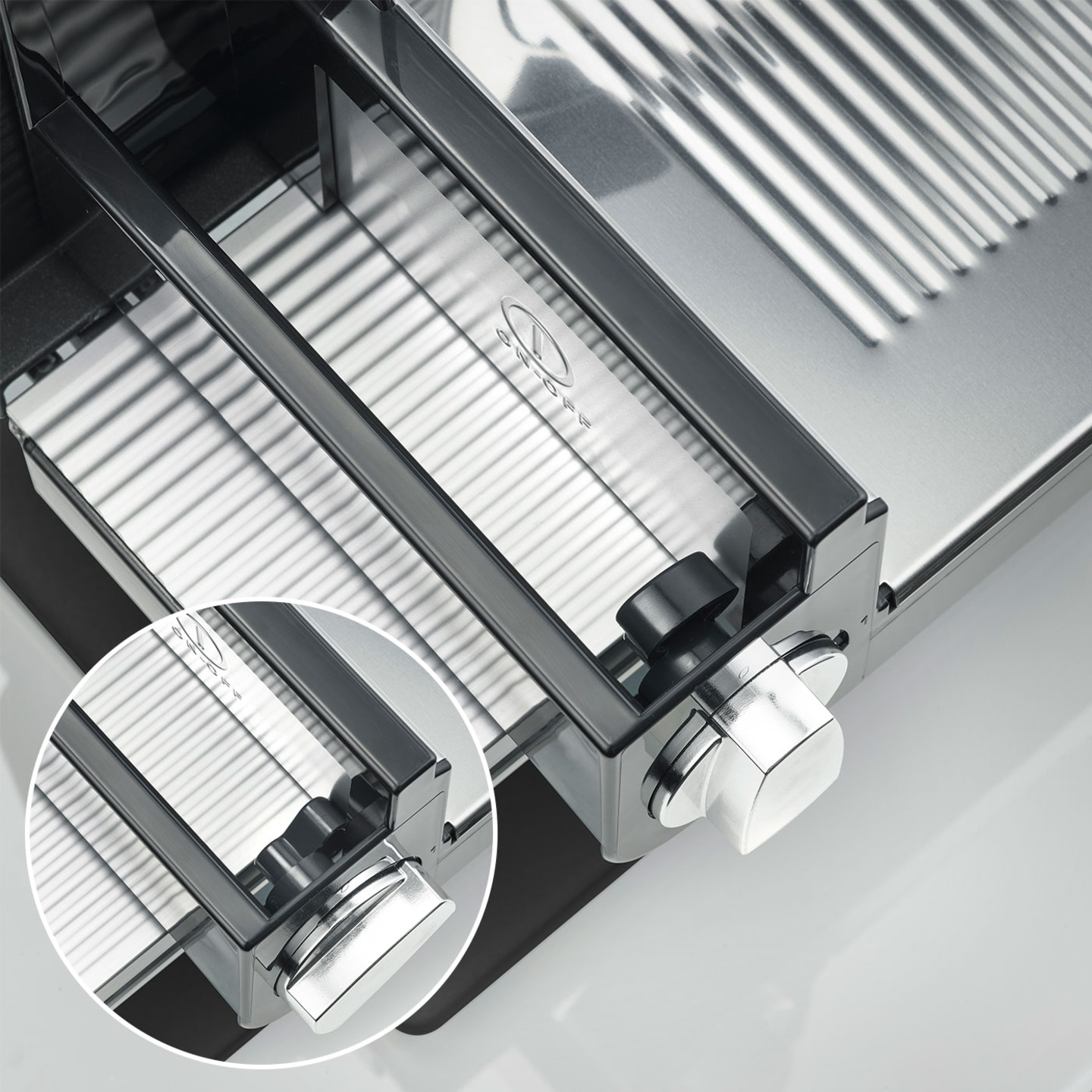 Nahaufnahme eines silbernen Fleischschneiders mit Knöpfen und Details