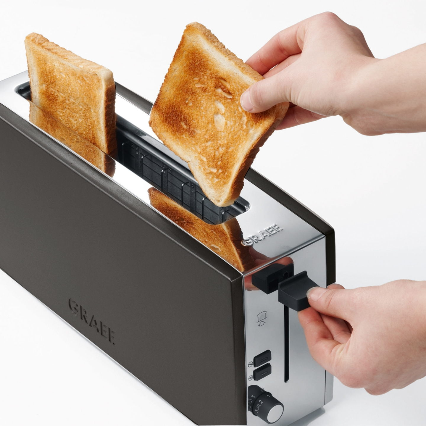 Ein Toaster mit Toastbrot, das aus dem Toaster genommen wird, Nahaufnahme.