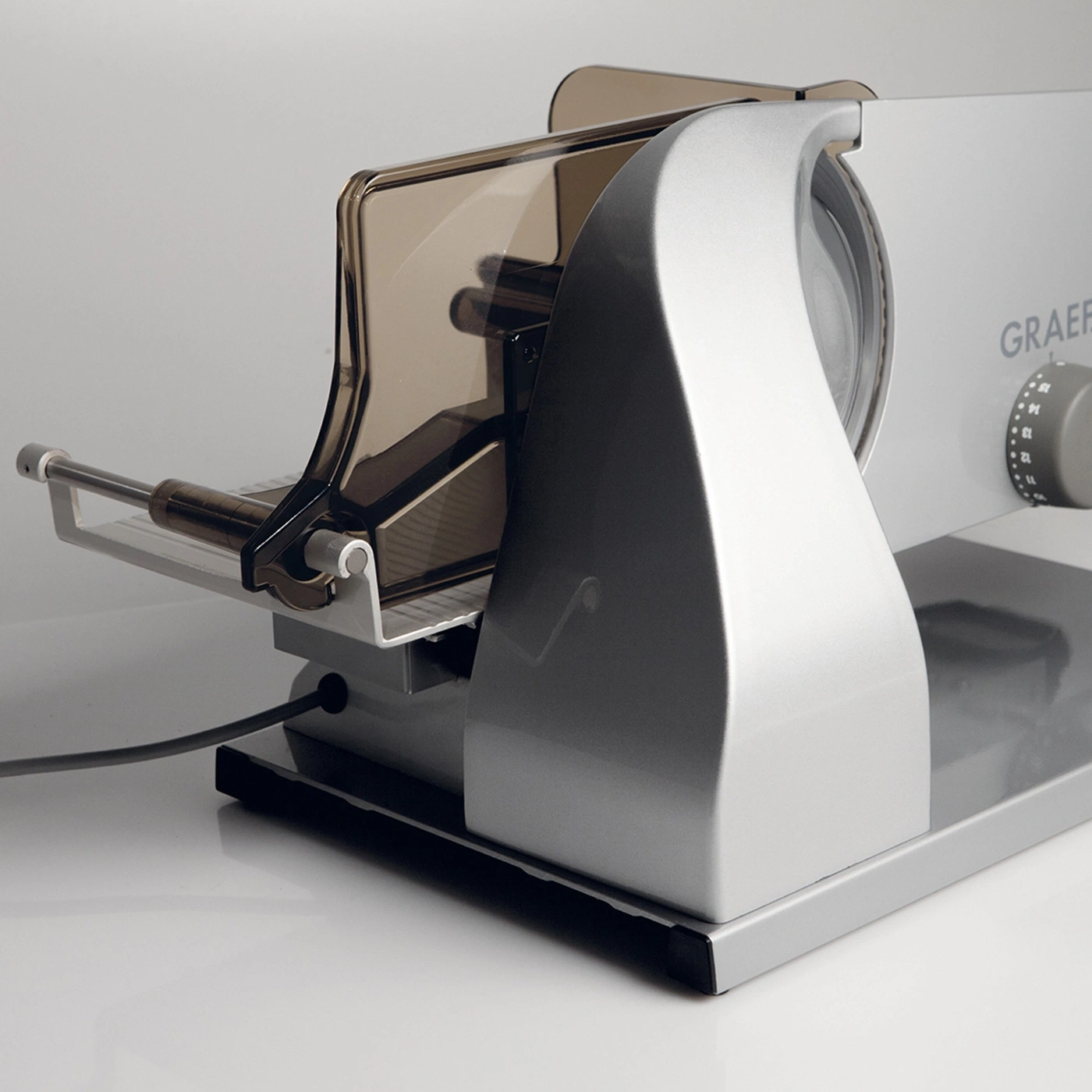 Silver Graef slicer with safety guard and dial for thickness adjustment, close-up shot