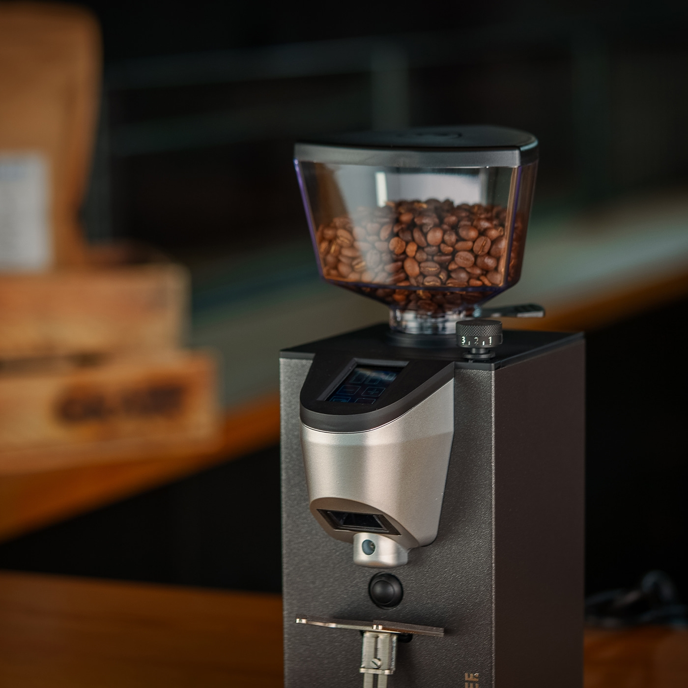 Coffee grinder with roasted coffee beans in the hopper, close-up shot