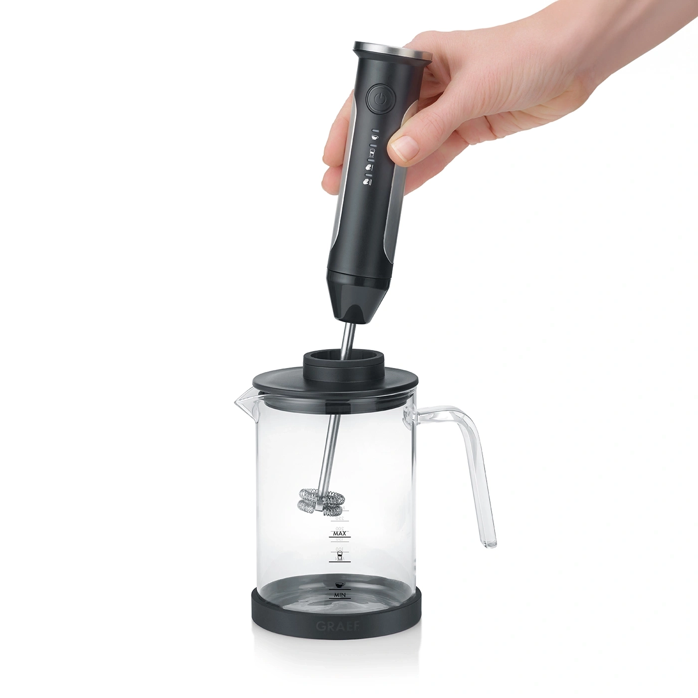 Milchaufschäumer mit Glasbehälter und Hand, bereit für die Zubereitung von Kaffee