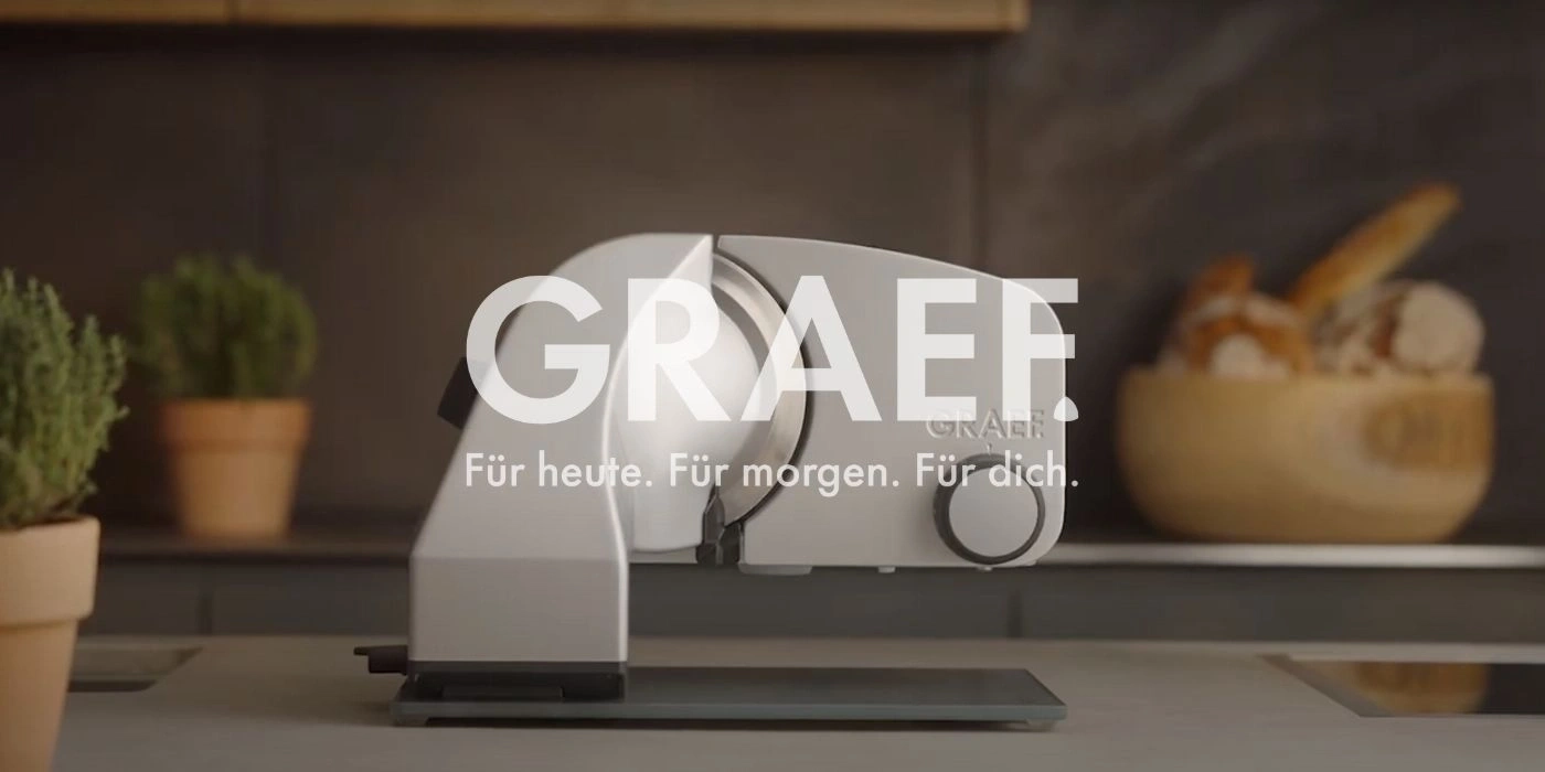 Graef slicer in a kitchen with bread and plants in the background