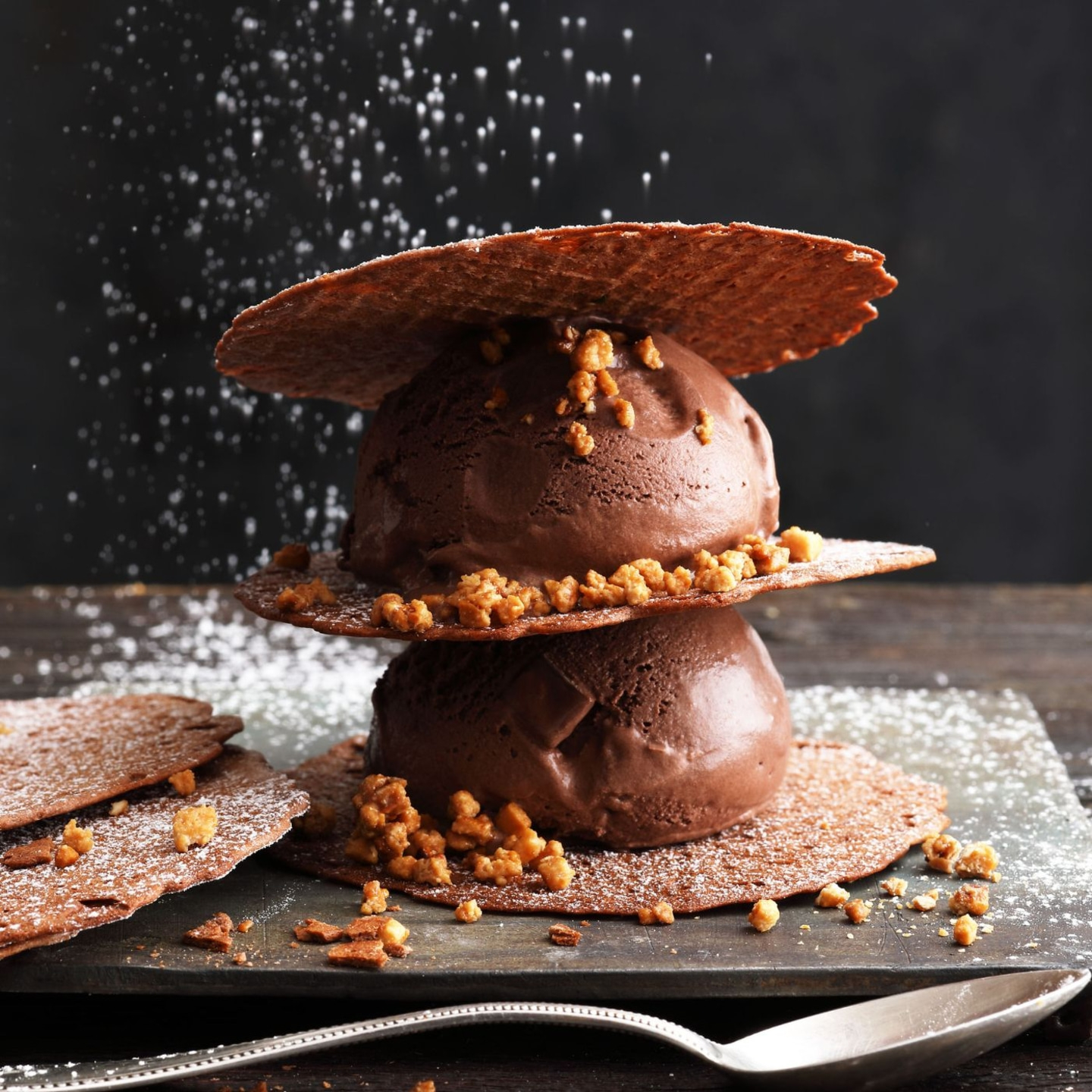 Schokoladeneis mit Waffeln und Streuseln, dekoriert mit Puderzucker