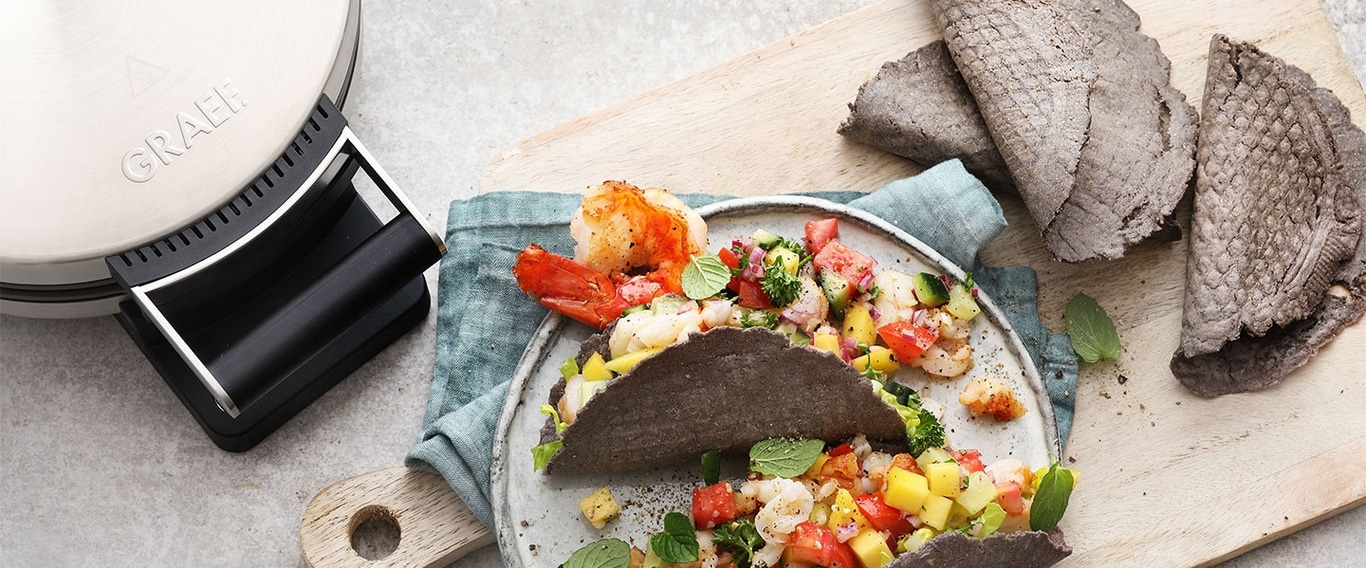 Gegrillte Garnelen-Tacos mit Mango-Salsa auf einem Teller mit Tortillas