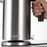 Edelstahl-Wasserkocher mit Griff und Logo, gehalten von einer Hand.