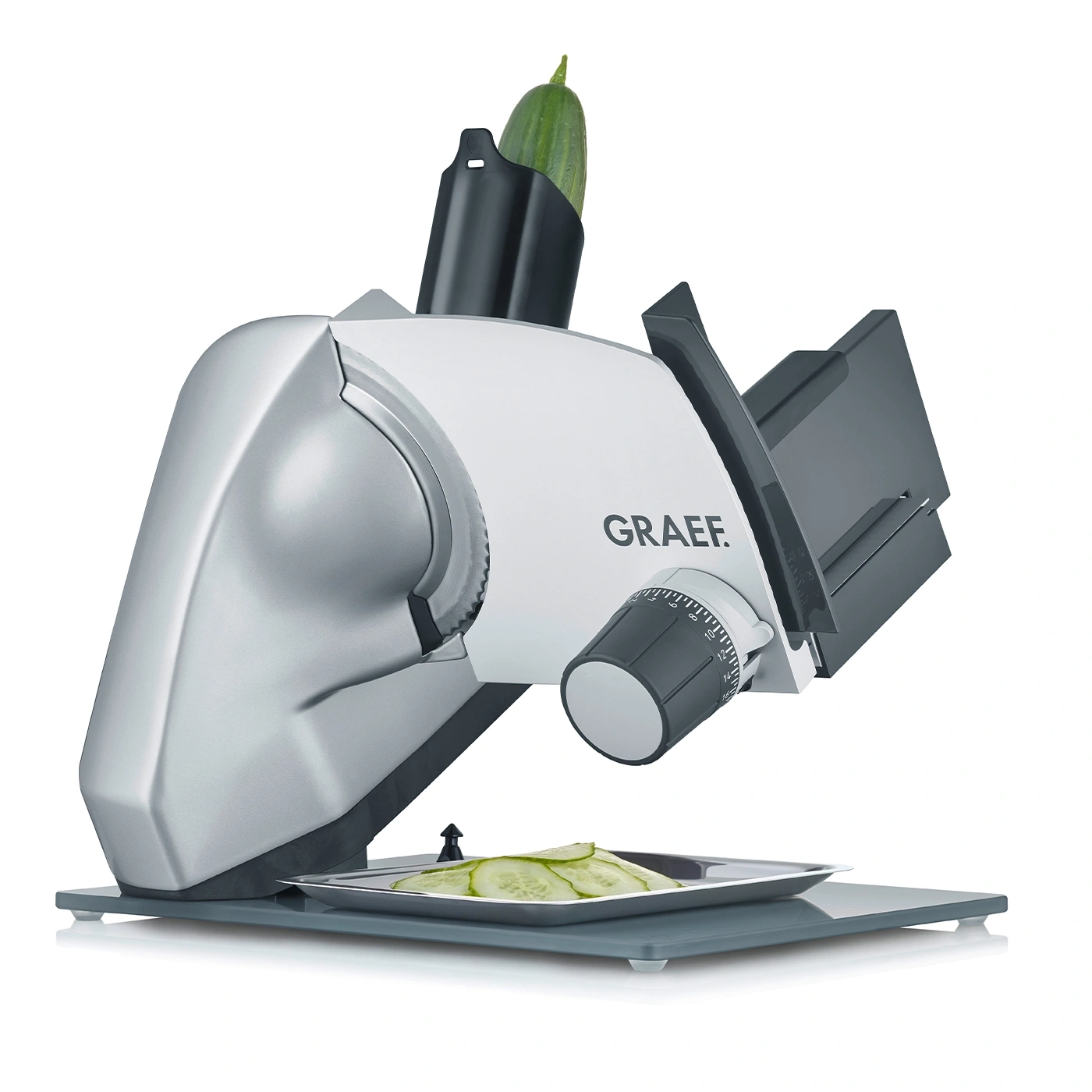 Vegetable slicer with cucumber and sliced cucumber on a tray