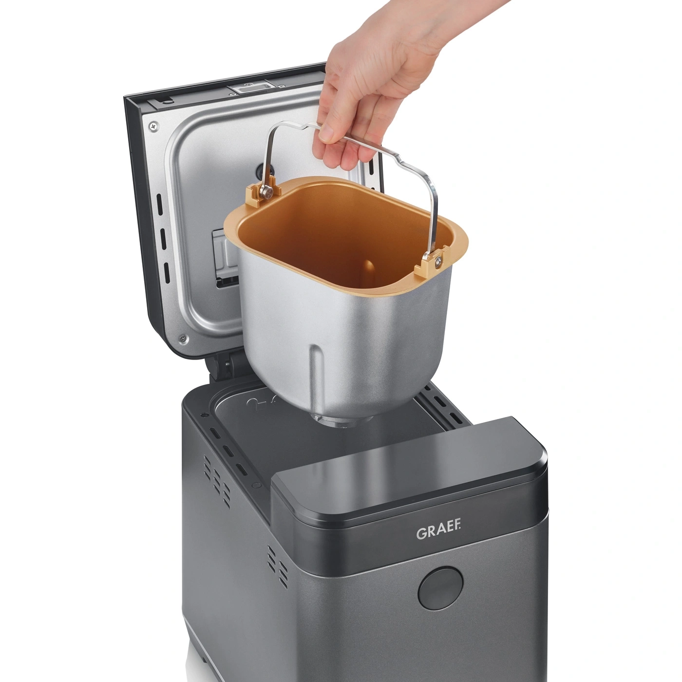 Brotbackautomat mit herausnehmbarem Behälter, Hand hält Griff, geöffnet