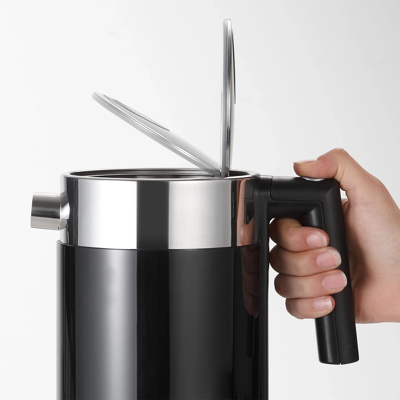 Black kettle with open lid held by a hand, shiny metal and black plastic.