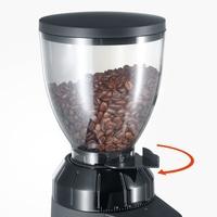 Kaffeemühle mit Bohnen, schwarzer Behälter, Mahlgrad einstellbar, Pfeil zeigt Richtung