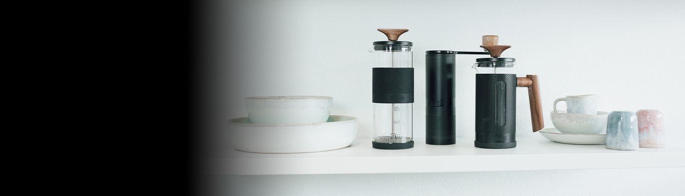 Coffee grinders and ceramics on a shelf, minimalist and stylish, white background.