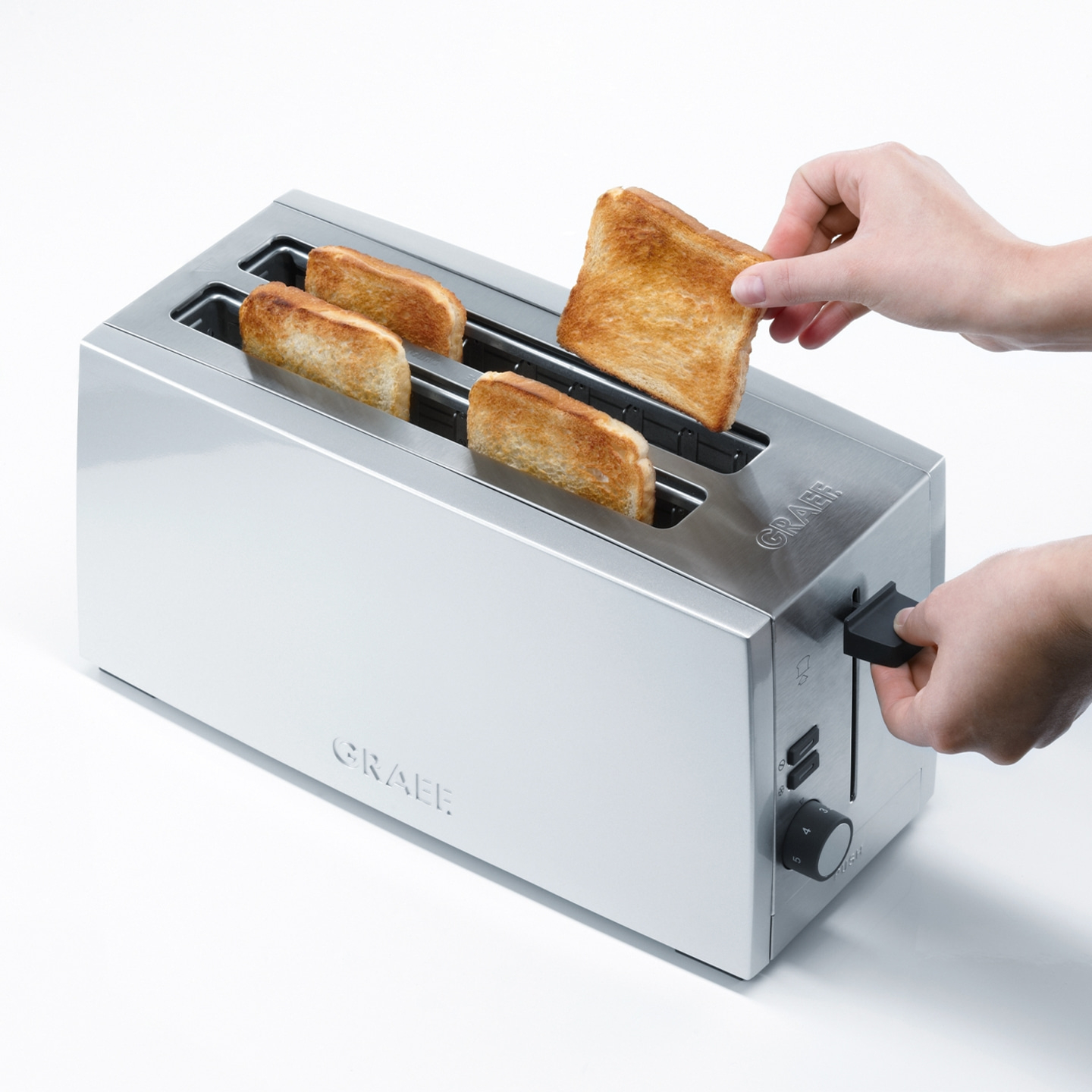 Ein Toaster mit Toast, eine Hand nimmt Toast heraus, silbernes Gerät, GRAEF.