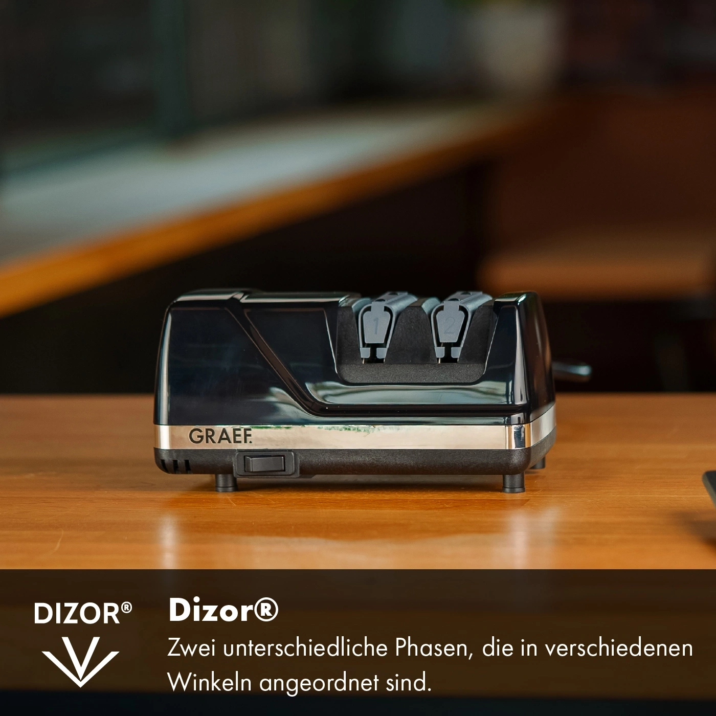 Black Graef knife sharpener on wooden surface with text and logo