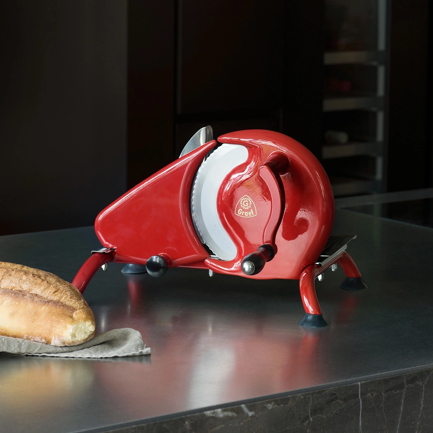 Ein roter Graet Brotschneider mit einem Brot auf einem Tuch.