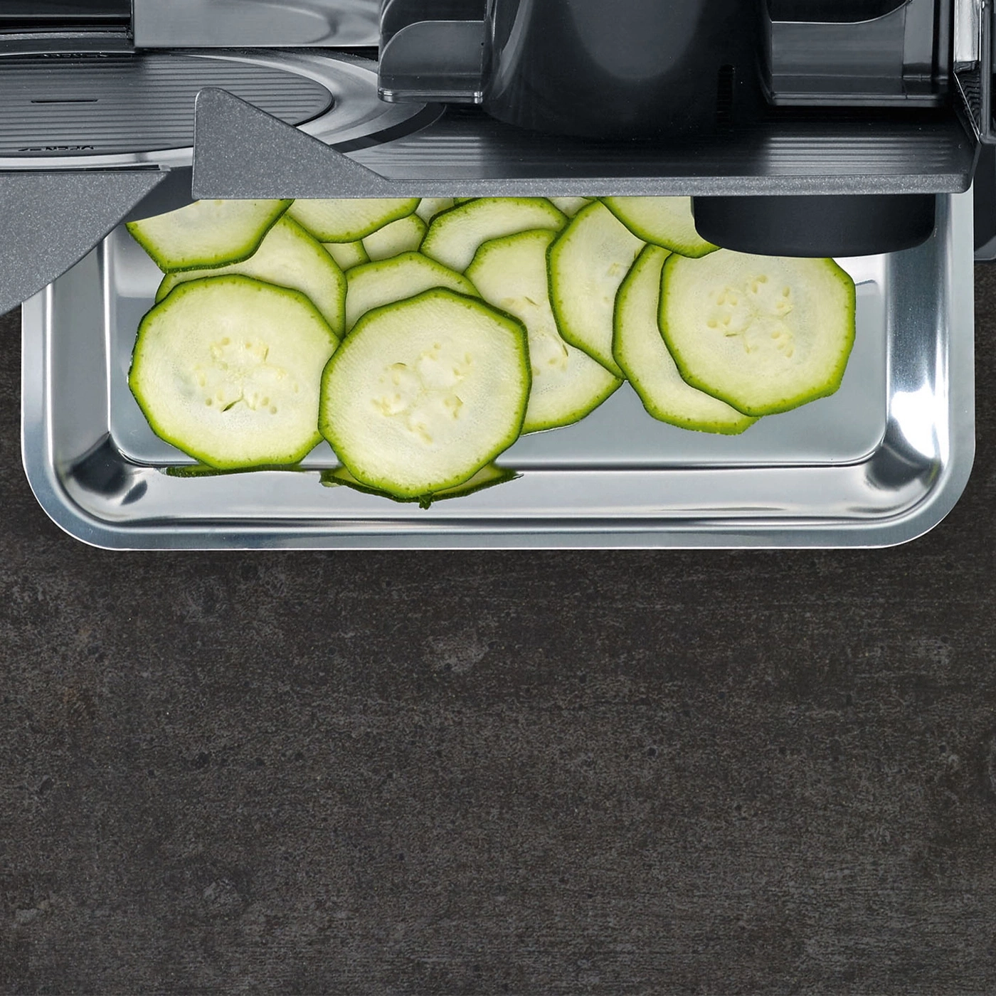 Thinly sliced zucchini in a metal tray, ready for cooking.