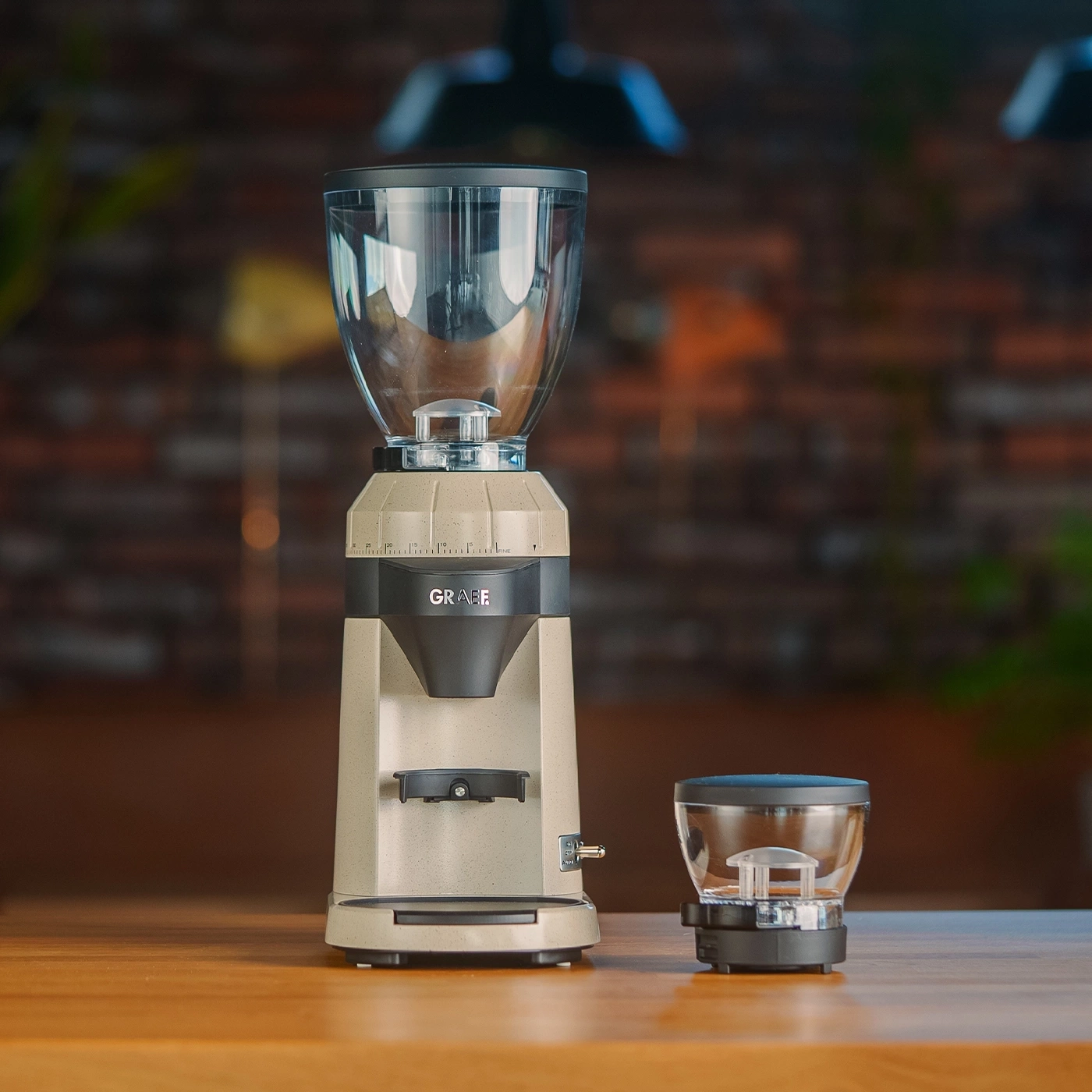 Eine Kaffeemühle mit Behälter auf einem Holztisch.
