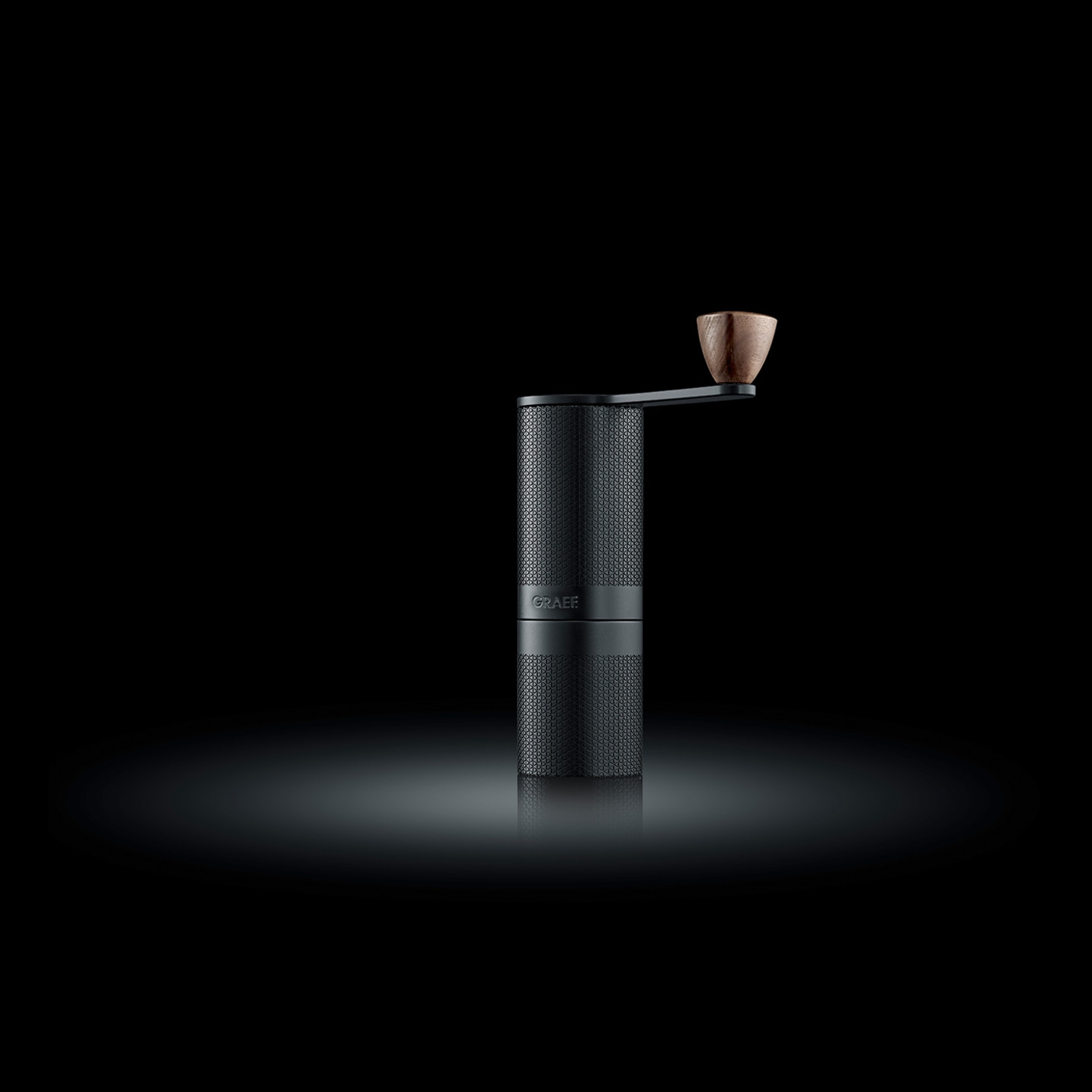Black coffee grinder with wooden handle, minimalist and elegant, on a black background.