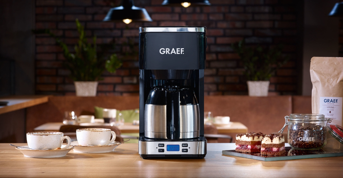 Kaffeemaschine mit Zubehör auf einem Holztisch in einem Café