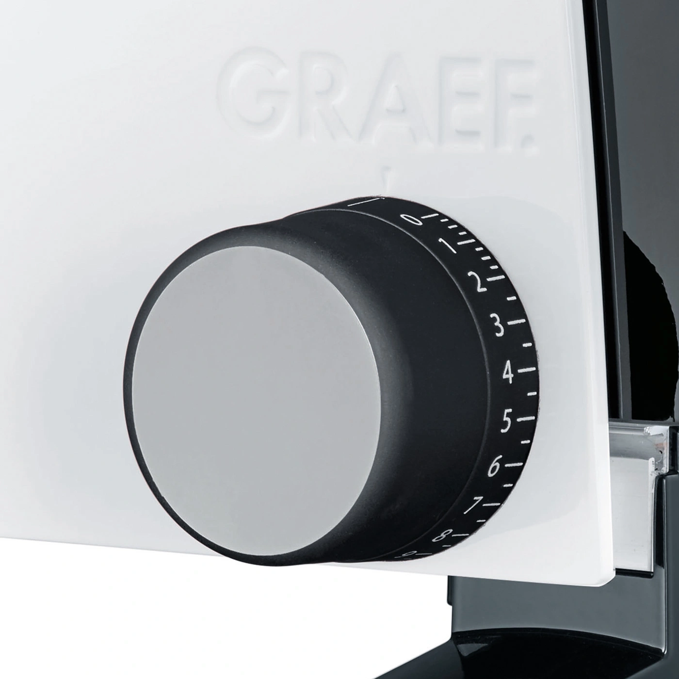 Close-up of a dial with a scale on a white surface with the GRAEF lettering.