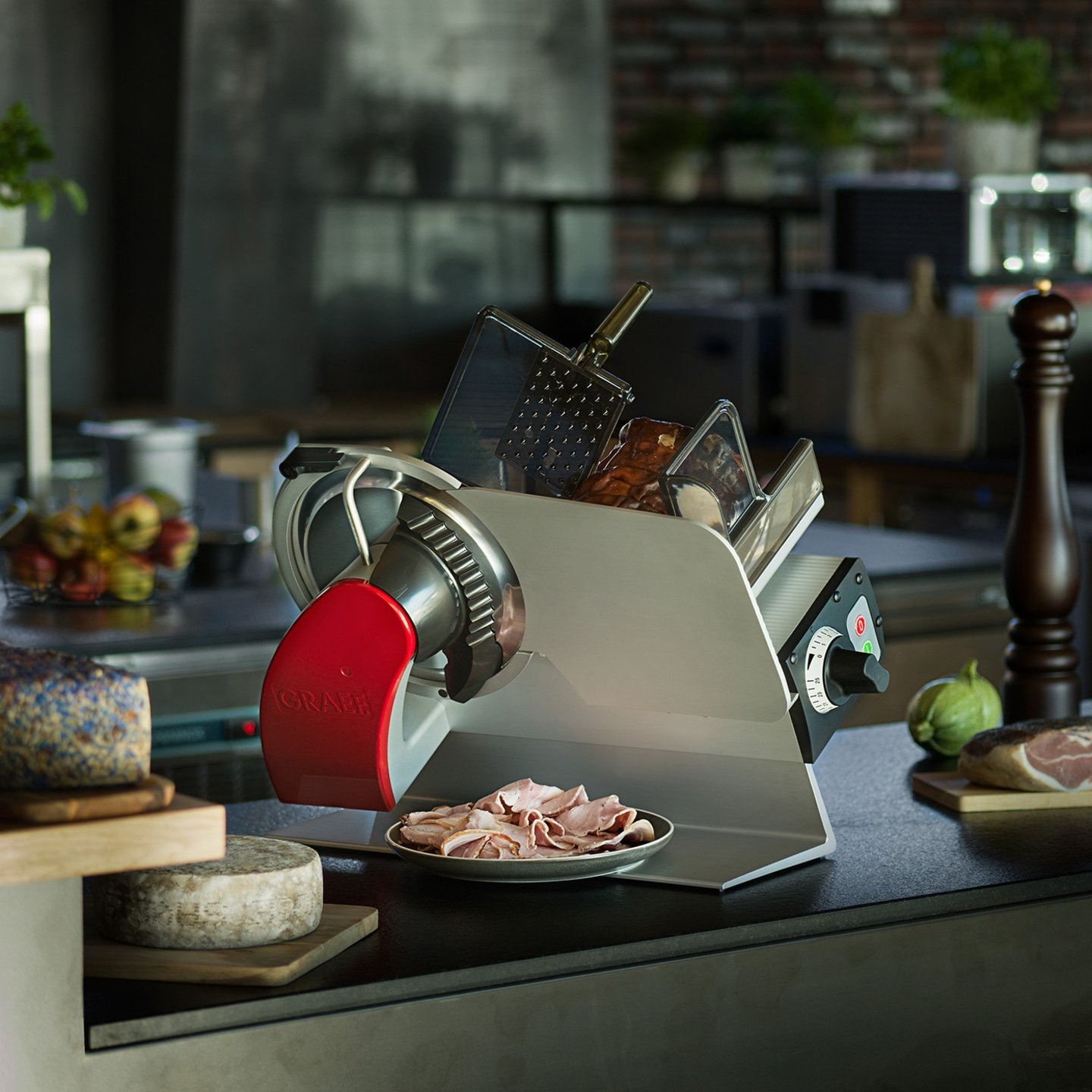 Fleischschneidemaschine mit Käse und Wurst auf einem Tisch in der Küche