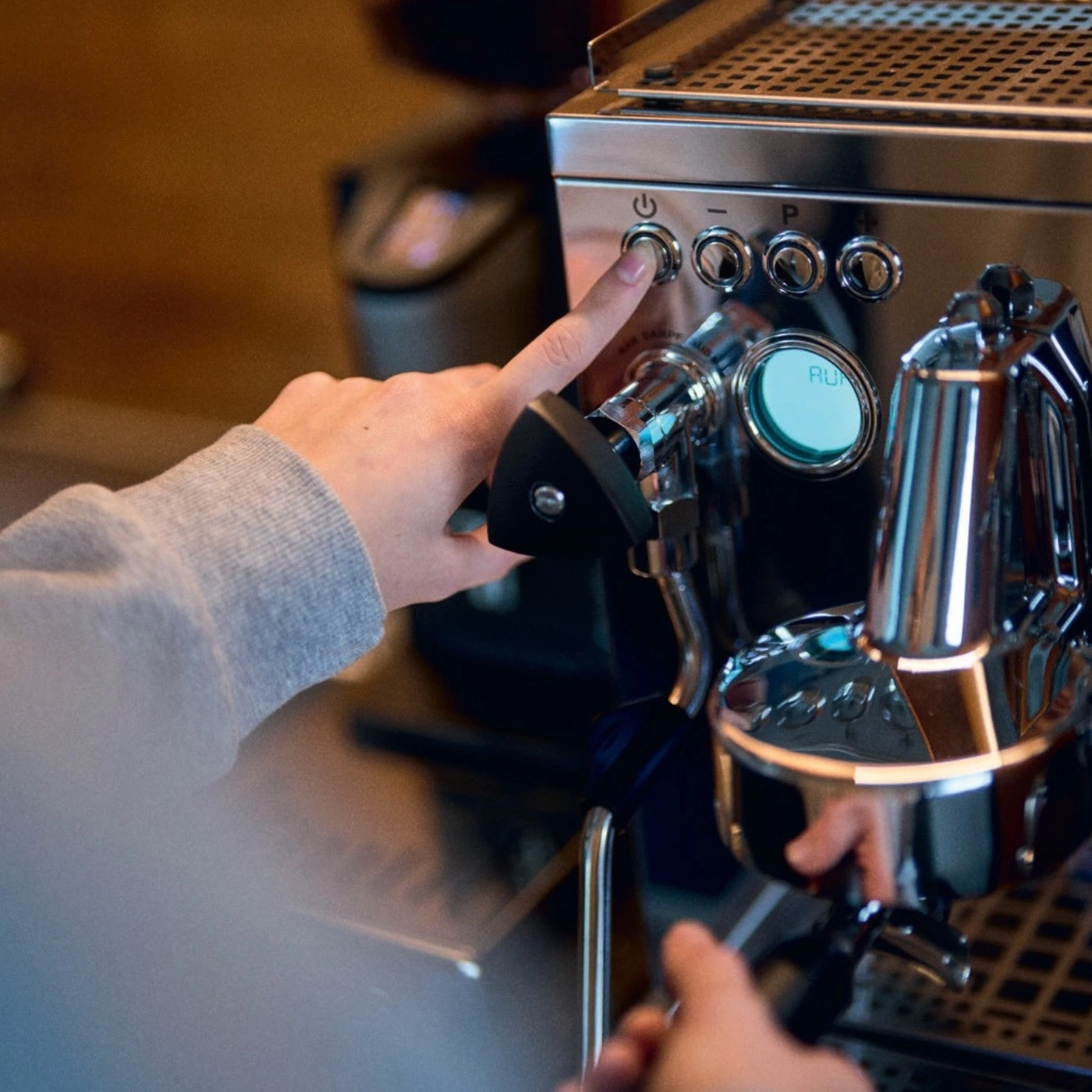 Person pressing button on coffee machine, close-up, hands, machine, start
