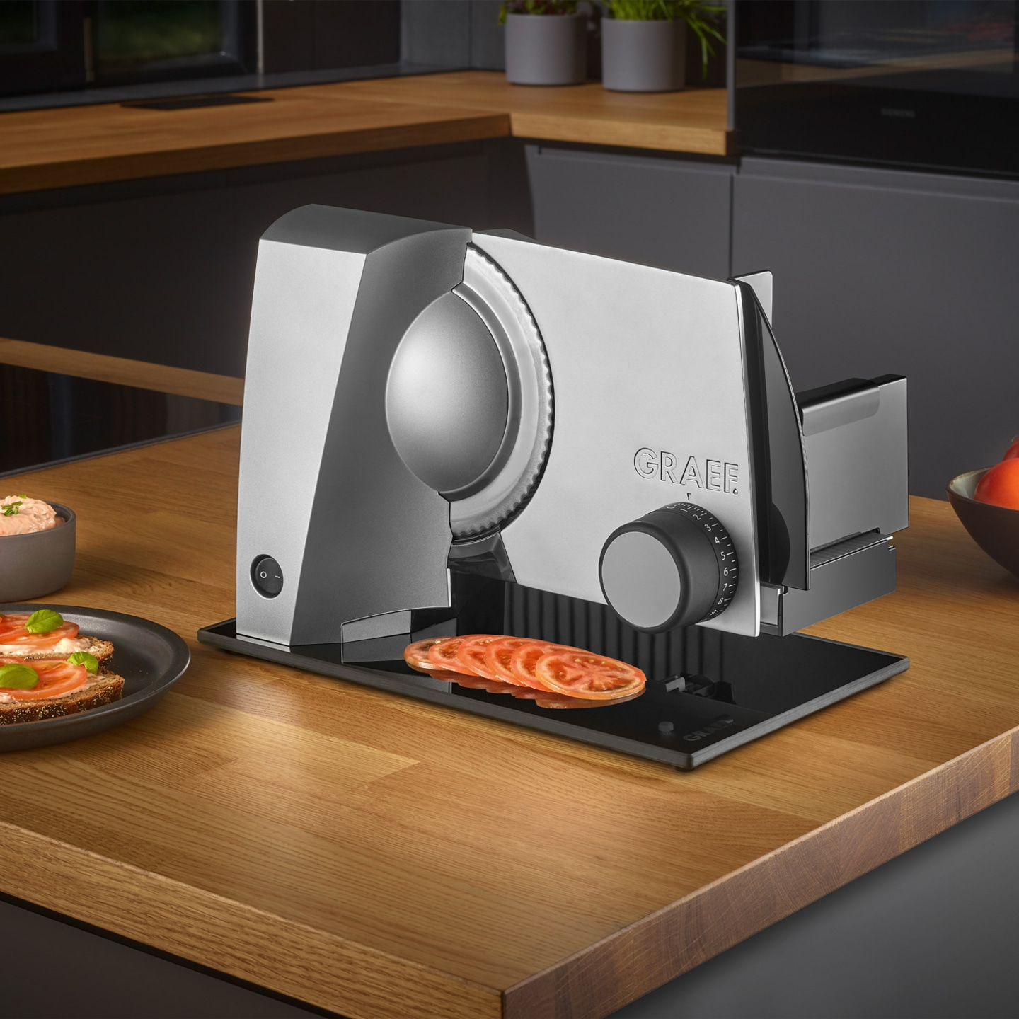 Graef Allesschneider mit Tomatenscheiben auf Holzoberfläche und Brot