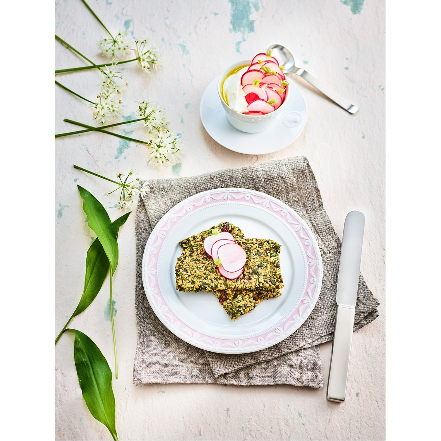 Delicious food with radishes and herbs on a plate, decorated with flowers