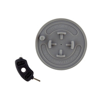 Graue Scheibe mit Aufschrift und schwarzem Reinigungsstift für Kaffeemaschine.