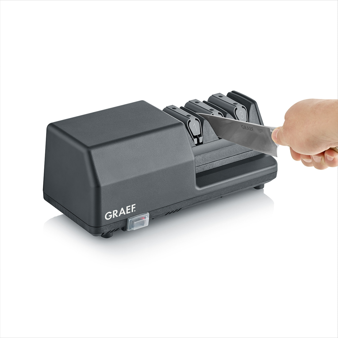 Graef knife sharpener with knife and hand, gray color, white background
