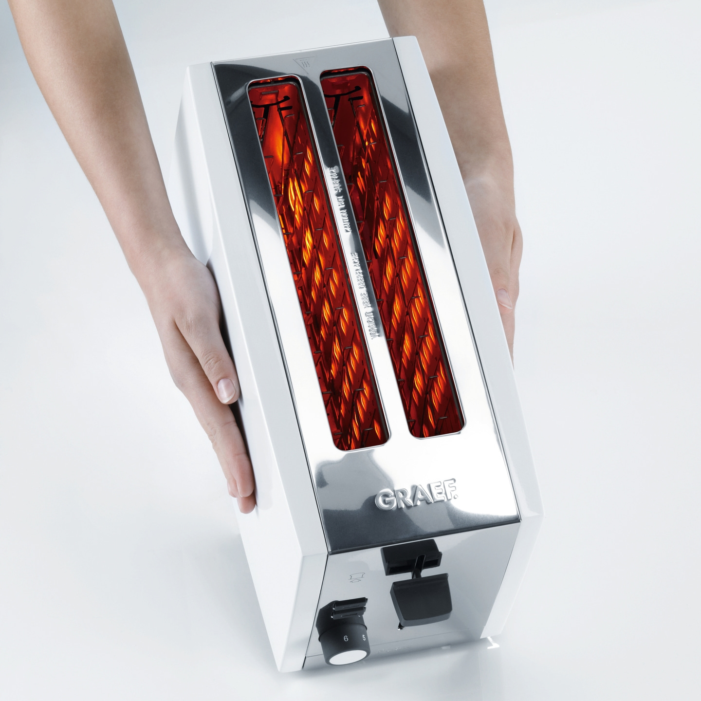 Toaster mit Händen gehalten, weiß und glänzend, mit rotem Licht im Inneren.
