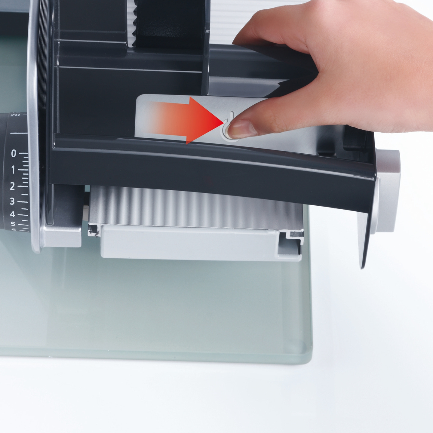 Nahaufnahme einer Person, die einen Knopf an einem Schneidegerät drückt.