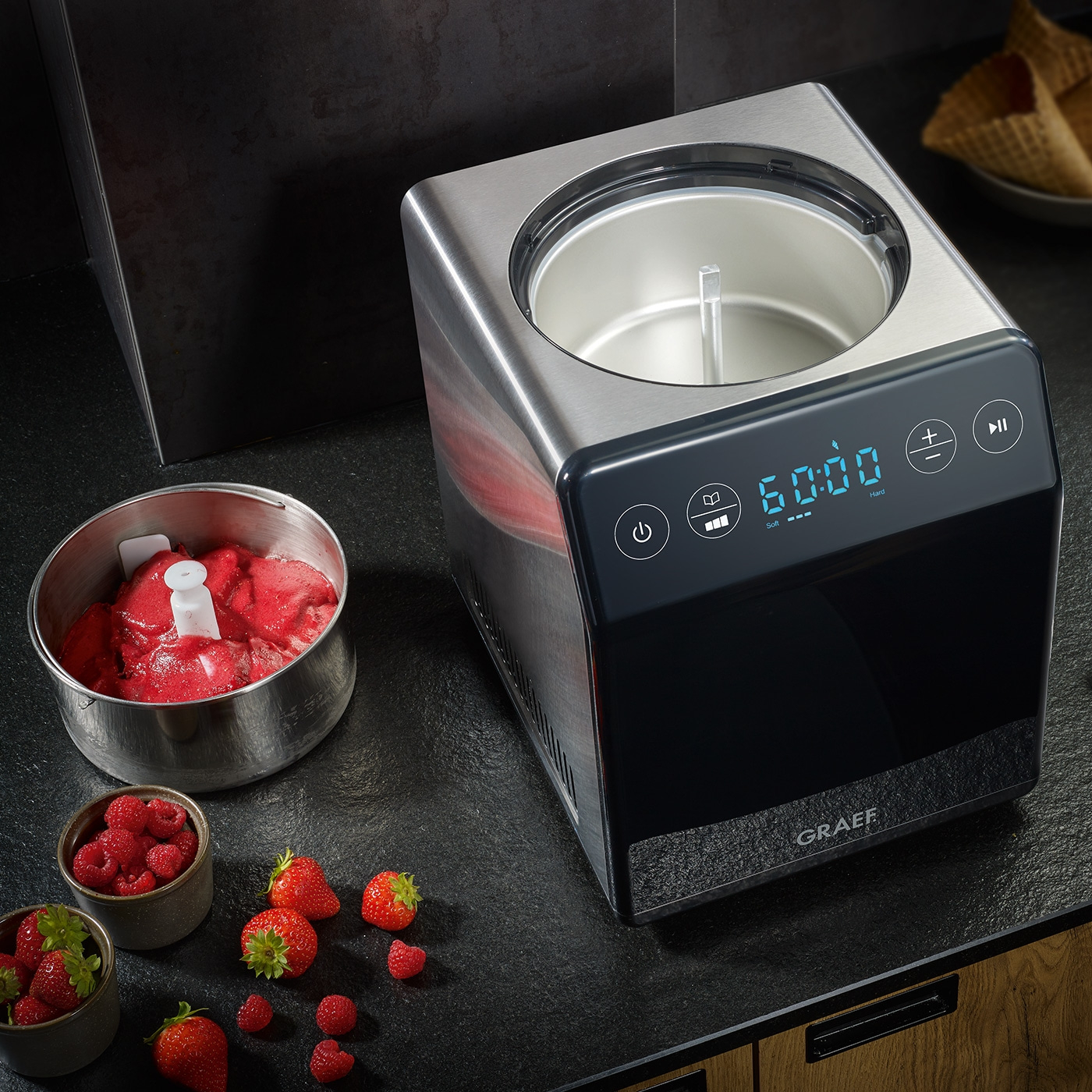 Eismaschine mit Früchten. Erdbeeren, Himbeeren und Eiscreme. Graef-Gerät.