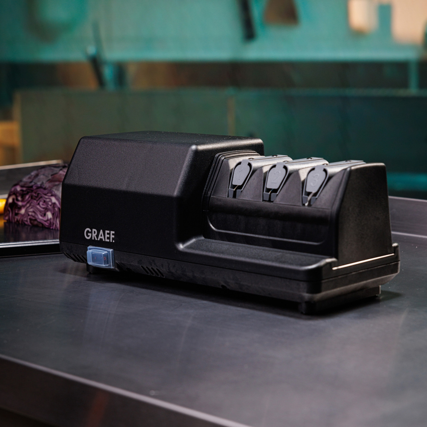 Black electric knife sharpener with GRAEF logo on a metal surface, close-up.