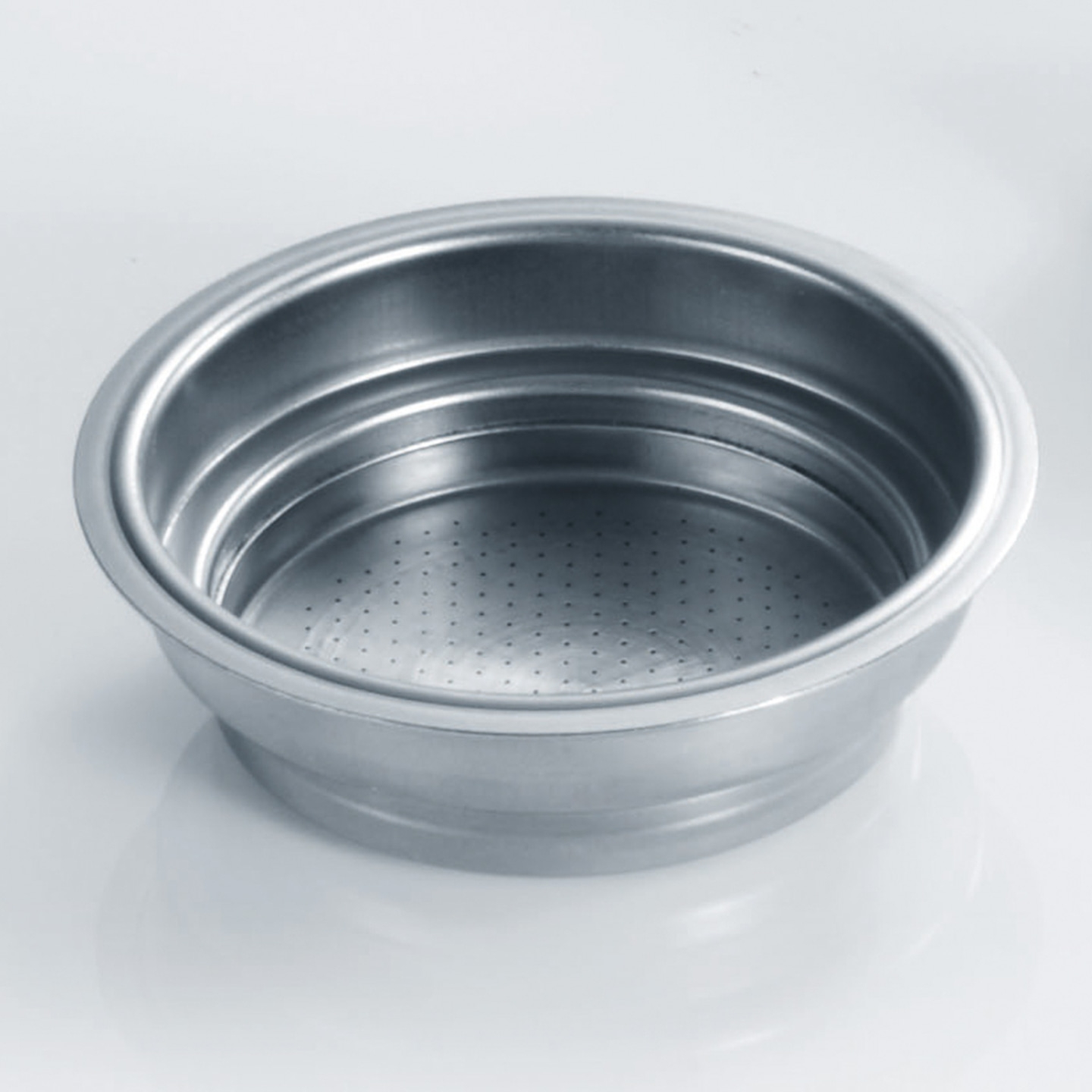 Edelstahl-Kaffeefilter, leer, mit Löchern, auf glattem, hellem Hintergrund