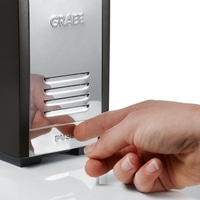 Hand drückt auf eine Maschine mit der Aufschrift GRAEF und PUSH.