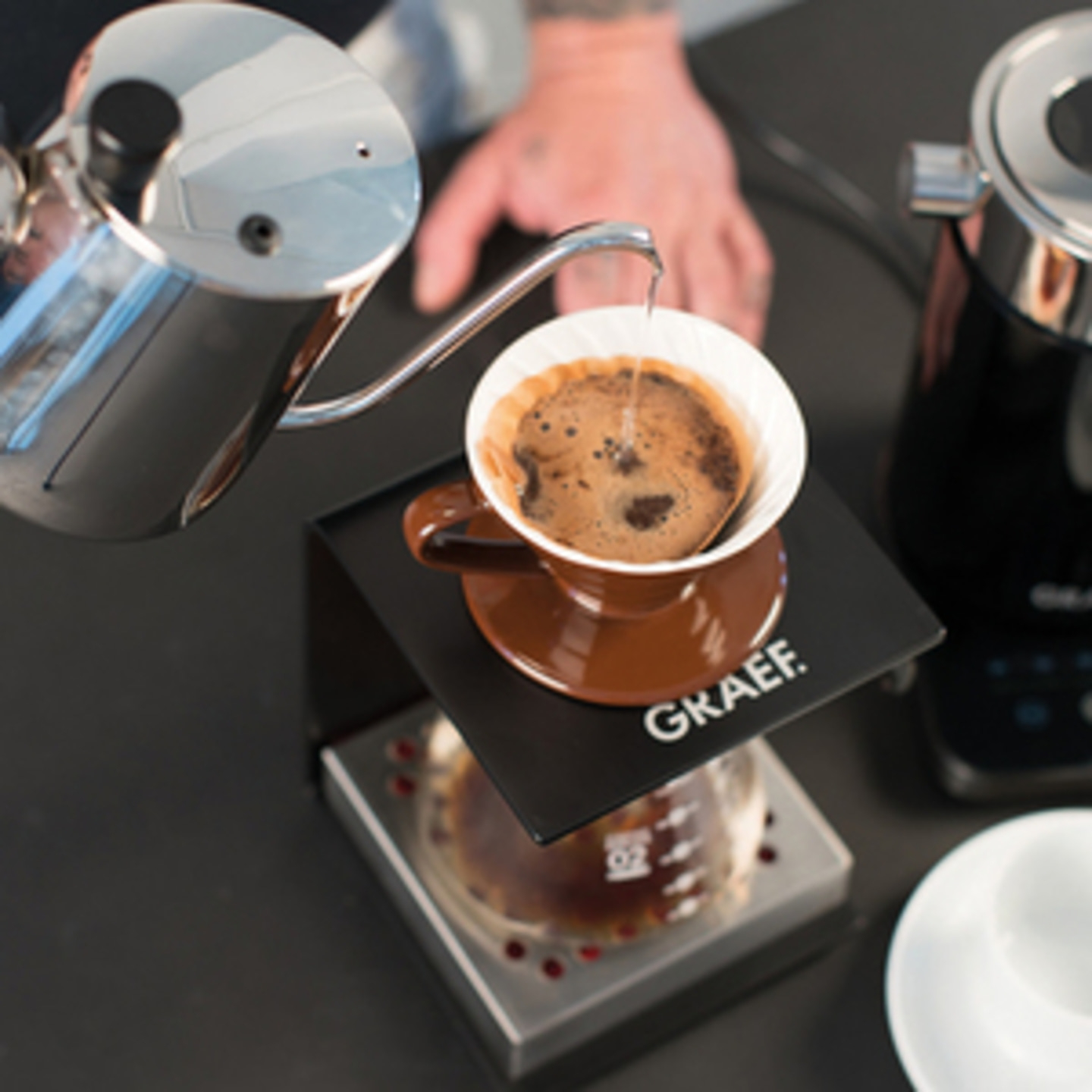 Kaffee wird in einem Brühvorgang in einer Tasse zubereitet, die auf einem Ständer steht.