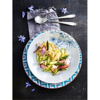 Spaghetti with asparagus and onions on a plate with flowers.