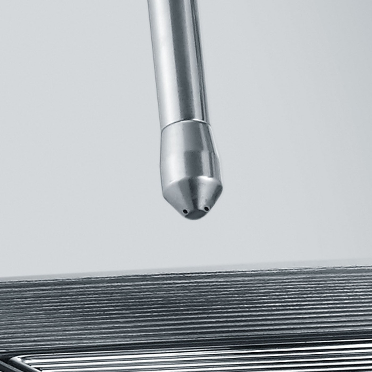 Metallrohr mit Düse, die auf eine Reihe von Metallplatten gerichtet ist