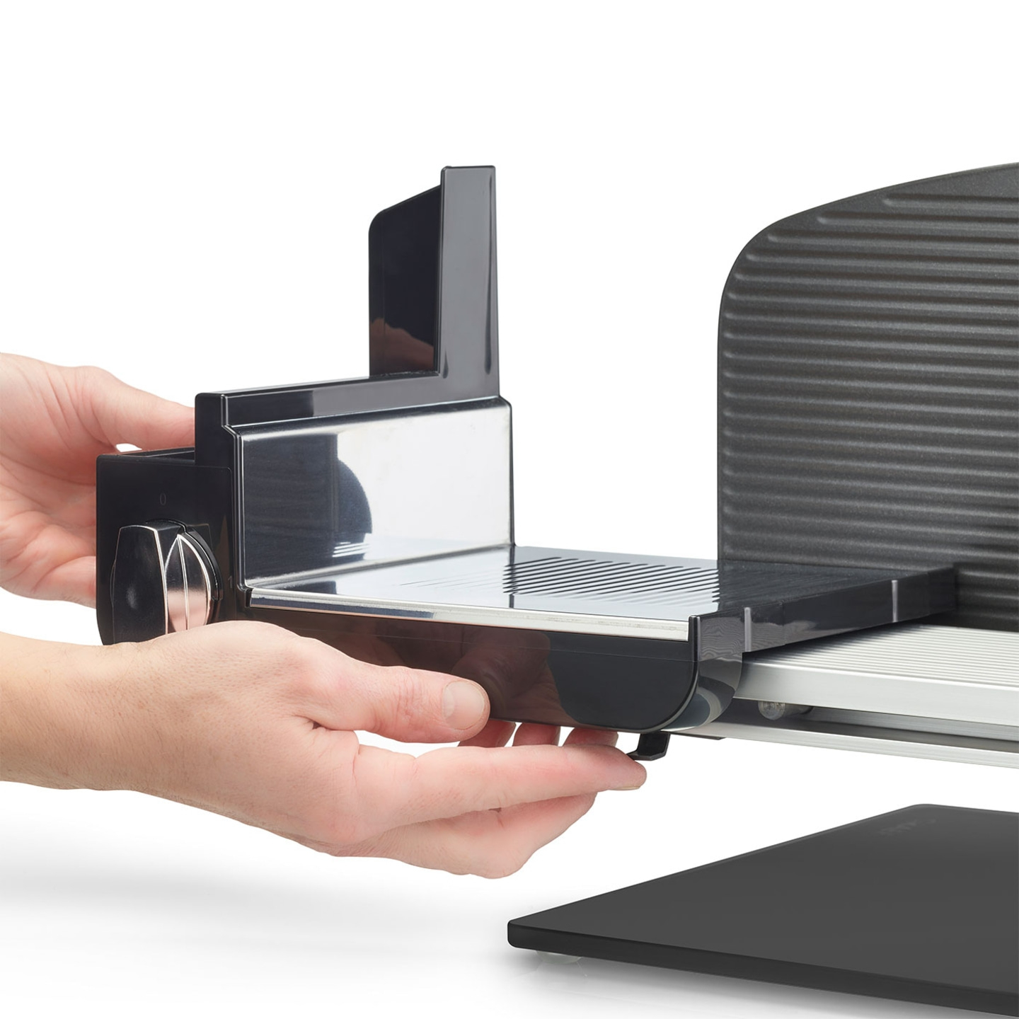 Nahaufnahme einer Person, die einen schwarzen Fleischschneider hält, der auf weißem Hintergrund isoliert ist.