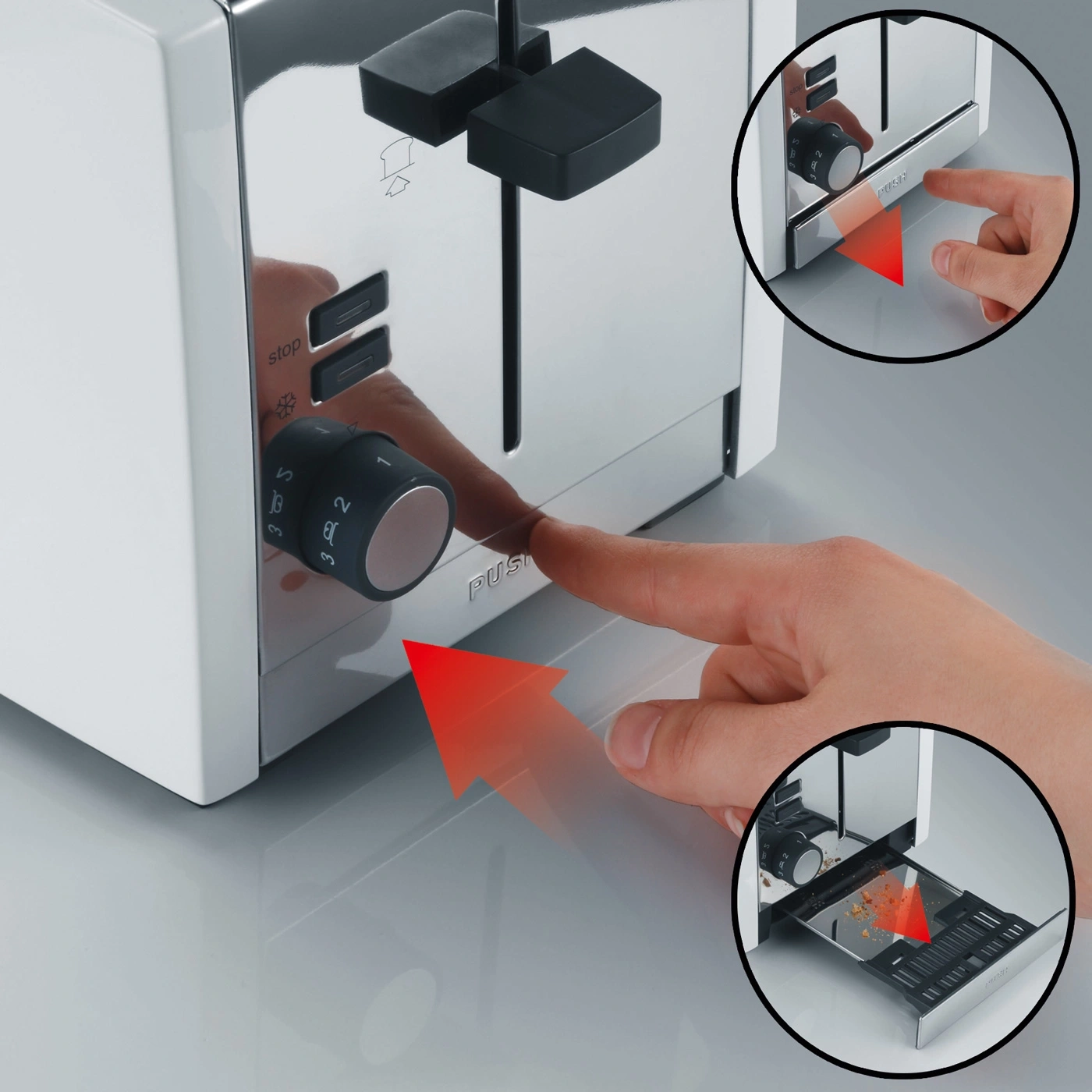 Ein Finger drückt den Knopf an einem silbernen Toaster mit Krümelschublade.
