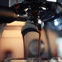 Espresso pouring from a coffee machine into a cup.